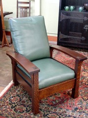 Additional view of same form in a lighter stain with green leather upholstery.